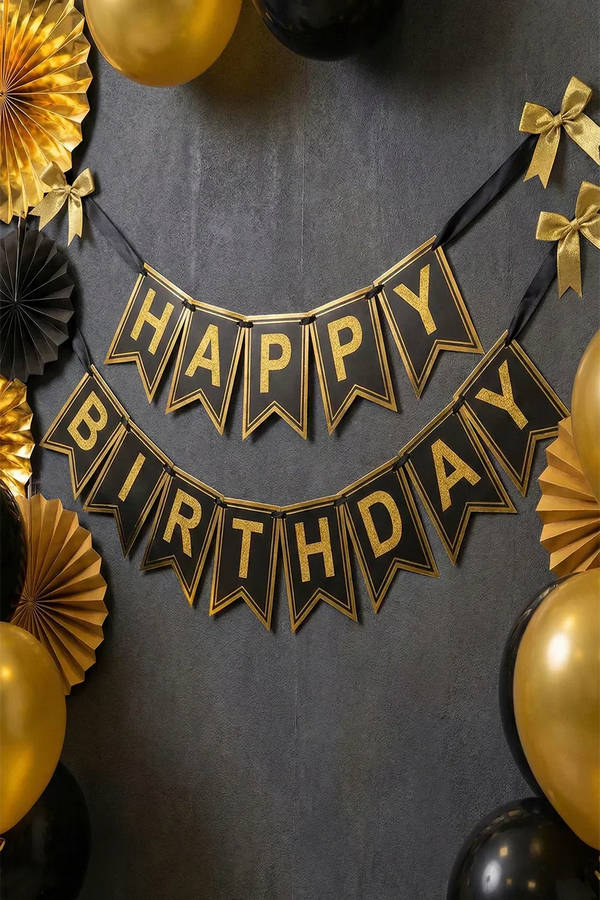 Gold and black layered Happy Birthday banner hanging on a wall