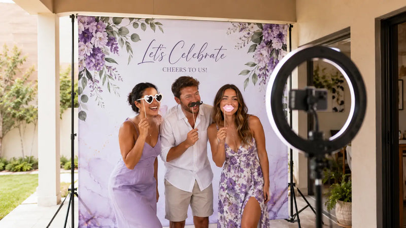 Friends taking a selfie in front of a beautiful custom party backdrop with ring light