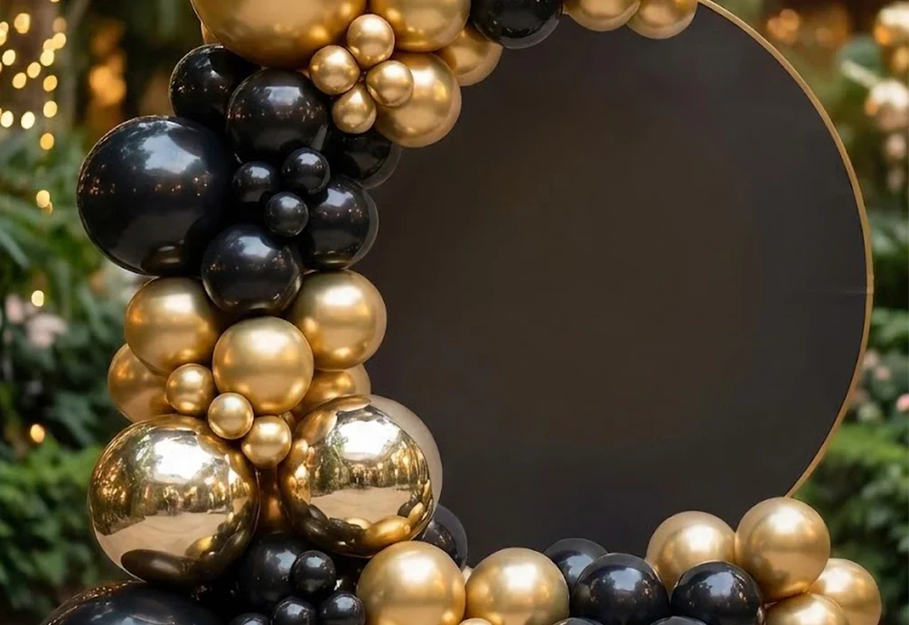 Organic gold and black balloon garland on a round backdrop