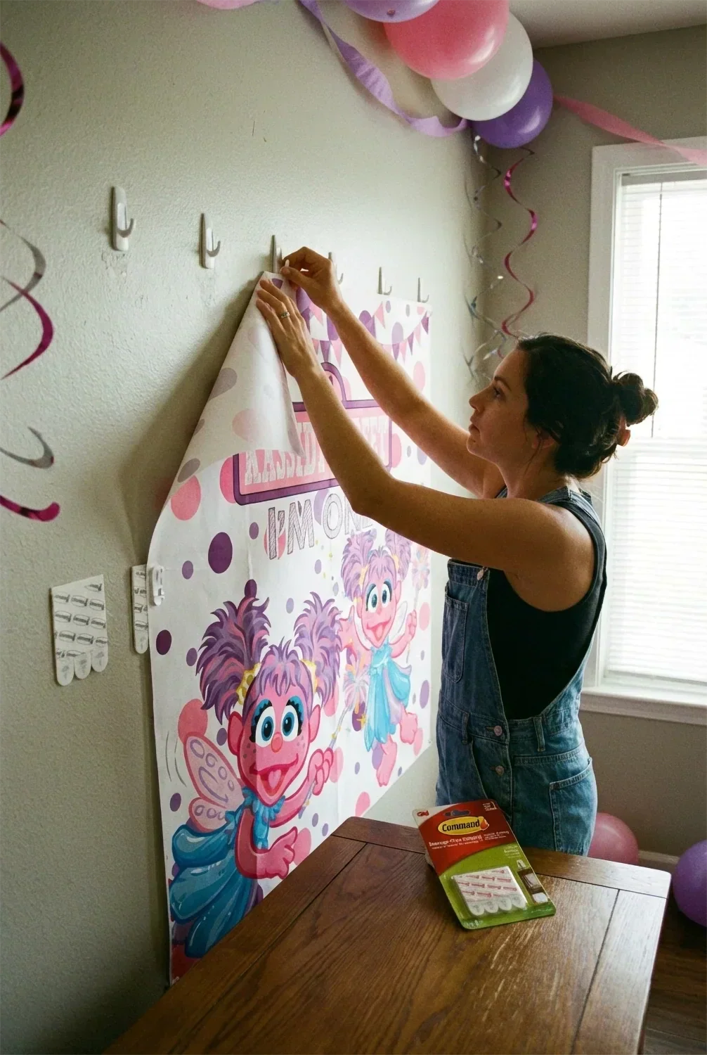 Person hanging a party backdrop using damage-free command strips